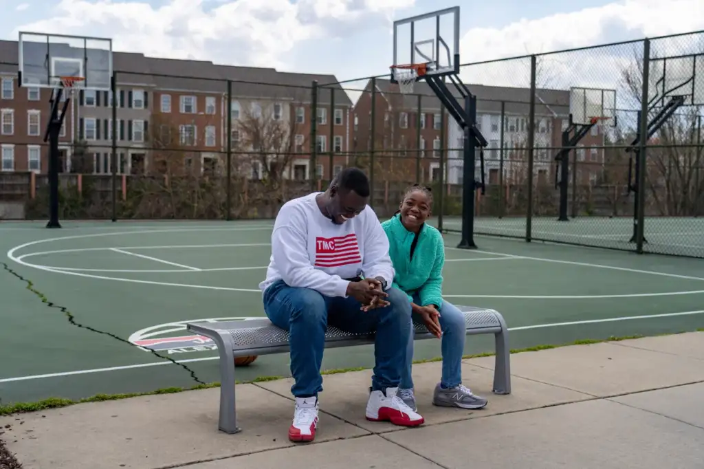 Joseph Yusuf sits with his daughter, Jakayla Morton, 11, at a basketball court in Alexandria, Va., on March 29.
Keren Carrión/NPR